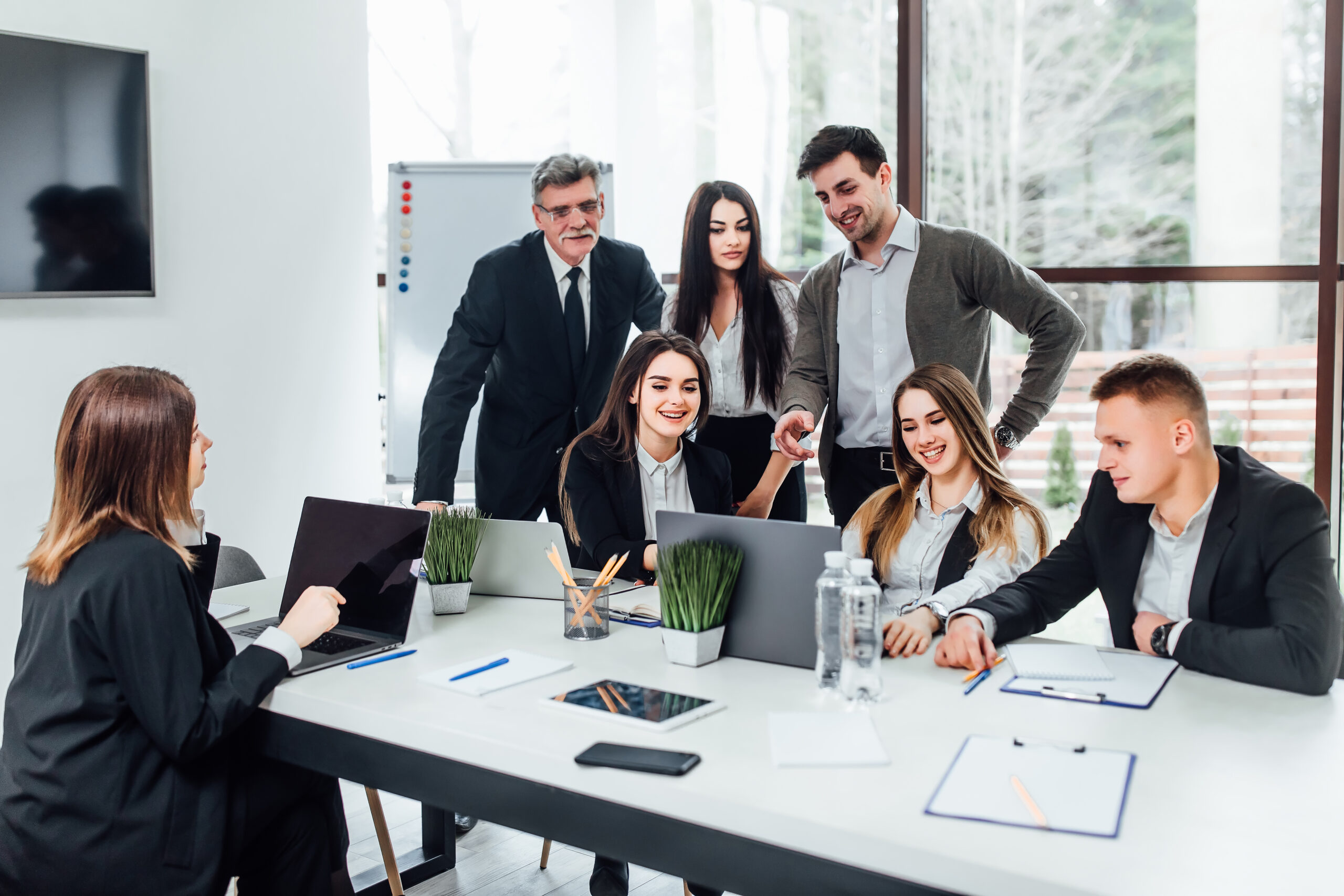 Staff meeting. Group of   young modern people in smart casual wear discussing something while working in the creative office . Business time..